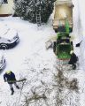 Работа измельчителя древесины.
Ветви перерабатываются и с помощью желоба
щепа подаётся в нужном направлении. В данном случае в кузов самосвала.
