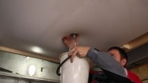 Слив воды с натяжного потолка.